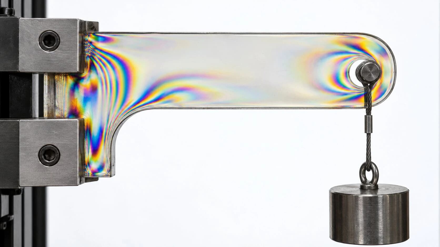 Farbige Spannungslinien in einem transparenten Bauteil unter polarisiertem Licht.